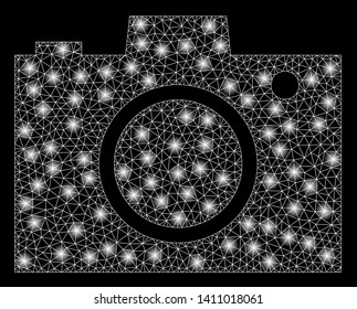 Bright mesh camera with lightspot effect. Abstract illuminated model of camera icon. Shiny wire frame polygonal mesh camera abstraction in vector format on a black background.