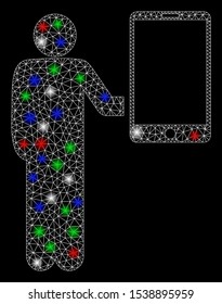 Bright mesh man holds smartphone with glow effect. White wire frame triangular mesh in vector format on a black background. Abstract 2d mesh designed with triangular lines, dots, colored flare spots.
