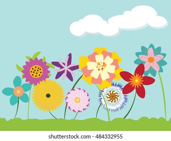 Bright multi-colored flowers sprouting up from grass against cloudy blue sky
