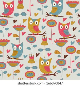 Bright seamless background with cute owls and flowers in cartoon style.