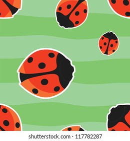 Bright seamless pattern with red ladybirds on green background