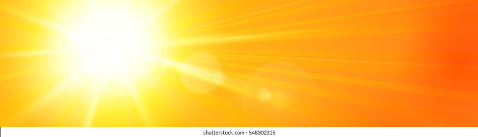 Bright sun left of the sky with sun rays and a lens flare in a vividly orange yellow sky. Panorama view for header, footer, or banner. Copy space