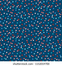 Bright wild polka dot surface pattern in red tones on dark blue background. Seamless repeat design, perfect for paper & fabrics.