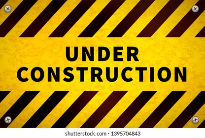 Bright yellow under construction warning sign with metal screws in corners