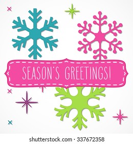 Brightly colored snowflakes and pink frame with hand written season's greetings, isolated over white.