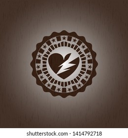 broken heart icon inside badge with wooden background
