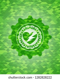 broken heart icon inside green emblem with triangle mosaic background