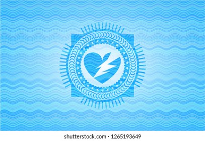 broken heart icon inside light blue water style emblem.