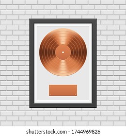 Bronze vinyl record with black frame on white brick wall