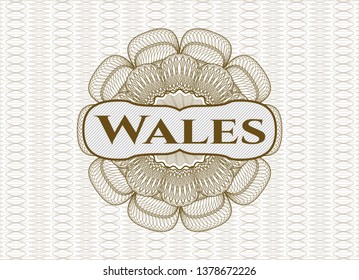 Brown abstract rosette with text Wales inside