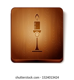 Brown Burning candle in candlestick icon isolated on white background. Old fashioned lit candle. Cylindrical candle stick with burning flame. Wooden square button. Vector Illustration
