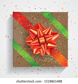 Caja de regalo marrón con gran arco rojo y cintas rojas y verdes aisladas en fondo blanco. Paquete Navidad y cumpleaños, selebración realista caja de regalo, vista superior