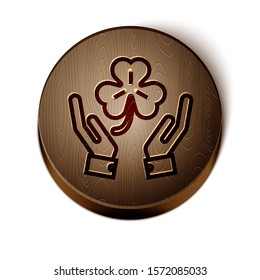 Brown line Human hands holding four leaf clover icon isolated on white background. Happy Saint Patrick day. Wooden circle button. Vector Illustration
