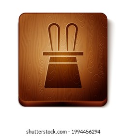 Brown Magician hat and rabbit ears icon isolated on white background. Magic trick. Mystery entertainment concept. Wooden square button. Vector