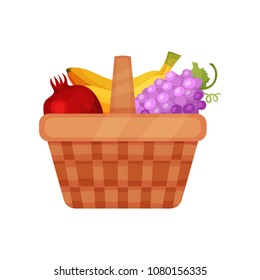 Brown picnic basket with sweet and fresh fruits. Pomegranate, bananas and grapes. Organic and healthy food. Flat vector icon