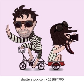 Brunet man with a beard and in sunglasses is riding on a bicycle and a girl in a white dress with a camera in hand follows him in the cart.