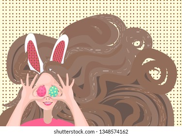 brunette girl with bunny ears on his head holding up a blue and pink Easter egg in front of her eye