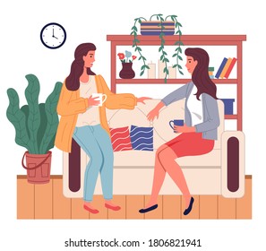 Brunette women girls sitting at sofa and talking. Friends relaxing at home with cup of tea or coffee. Happy girls spending leisure time at home. Sisters talking, relaxing at couch sofa in living room