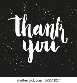 Brush lettering composition. Phrase - Thank you - on dark gray background with white ink splashes.