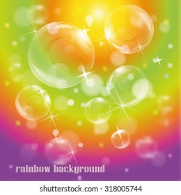 Bubbles on bright colorful rainbow background with glitters and starks