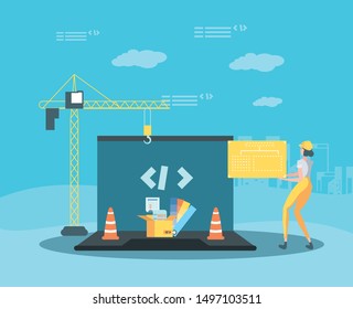 builder and laptop with webpage under cosntruction