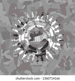buildings icon inside grey camouflaged emblem