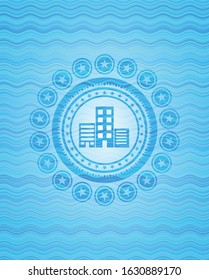 buildings icon inside light blue water emblem background.