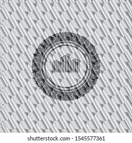buildings icon inside silver shiny badge. Scales pattern. Vector Illustration. Detailed.