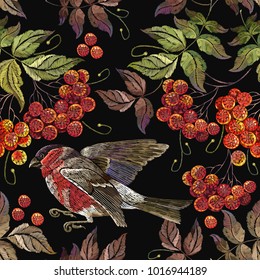 Bullfinch a branch of mountain ash berry pattern. Embroidery bird sitting on mountain ash branch seamless pattern. Fashionable template for design of clothes 