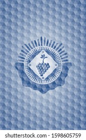 bunch of grapes icon inside blue emblem or badge with geometric pattern background.