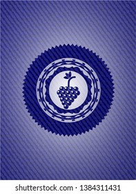 bunch of grapes icon inside emblem with jean background