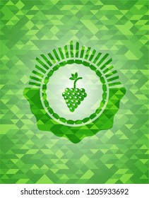 bunch of grapes icon inside green emblem with mosaic ecological style background