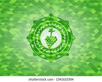 bunch of grapes icon inside green emblem with mosaic ecological style background
