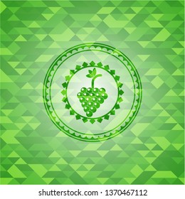 bunch of grapes icon inside green emblem with mosaic ecological style background