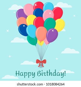Bunch of multi-colored balloons with a red bow, isolated on a background of the sky and clouds. Happy Birthday.