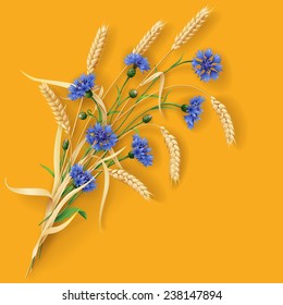 Bunch of wheat ears and blue cornflowers on orange background.