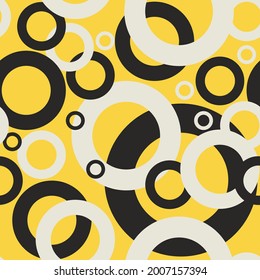 Bunch of white and black circles with different sizes on a yellow background seamless vector pattern design