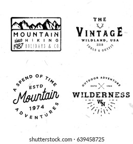 Bundle of wilderness badges, logos, design elements (mountain shapes, arrows, deer antlers). Vintage retro styled stock vector illustration