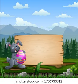 A bunny holding Easter Egg with blank wooden sign