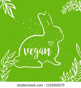 Bunny silhouette with lettering vegan and heart. Eco vegan cruelty free concept on green background with leaves.