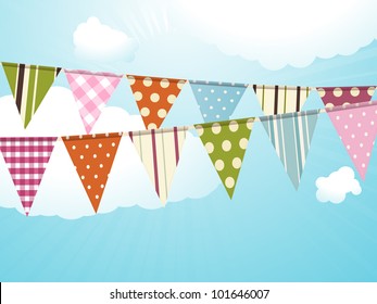 Bunting against a blue sky with fluffy clouds