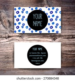 Business card template with watercolor pattern on wooden background
