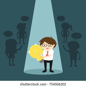 Business concept, Businessman standing alone in spotlight while holding big light bulb. 