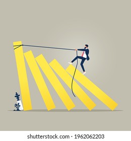 Business concept of a businessman trying to stop domino effect