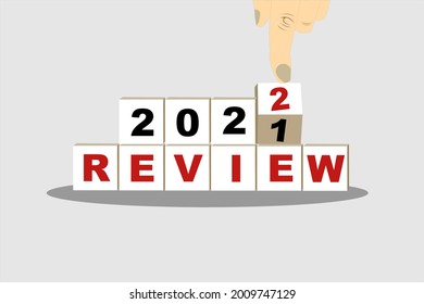 Business concept of planning 2022. Male hand flips a wooden cube and changes the inscription 'Review 2021' to 'Review 2022'. putih background, copy space.