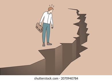 Business danger and challenge concept. Young frustrated businessman cartoon character standing looking at cracked ground abyss vector illustration