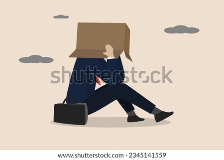 Business failure, work mistake, shame, bankruptcy or failed businessman concept, depressed businessman sitting alone covering his head with box in embarrassment to people.