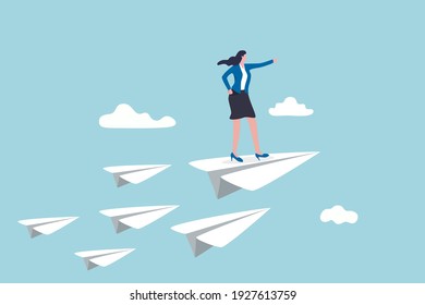 Business leadership, woman power to lead company to achieve target, smart confidence businesswoman standing on leading flying paper airplane origami pointing finger to the direction to reach goal. - Shutterstock ID 1927613759