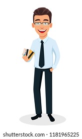 Business man cartoon character holding credit cards. Young handsome smiling businessman in office style clothes - stock vector