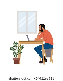 Business man sitting at desk, working on laptop. 